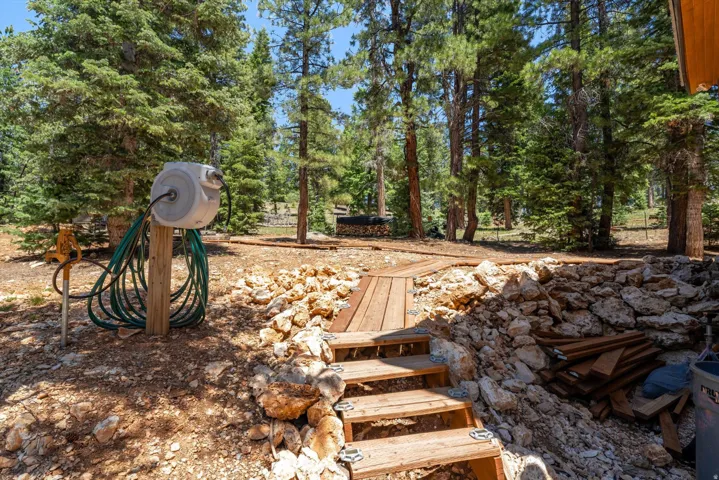Outdoor space featuring a wooden walkway and stairs, surrounded by natural rock formations