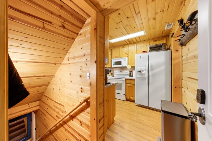 Wood-paneled interior featuring a staircase with a wooden handrail, leading to a lower level
