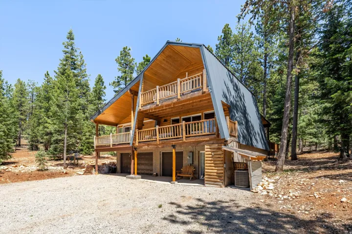 A-frame style residence featuring a metal roof and log siding