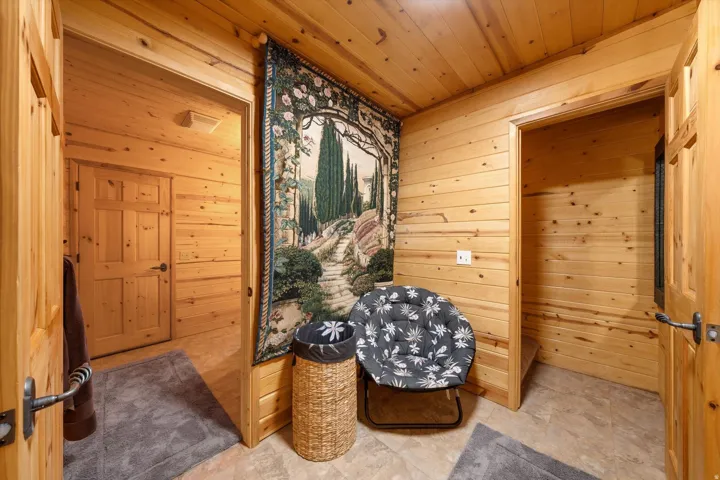 Interior hallway featuring plank wood walls and ceiling