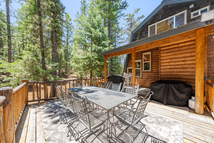 Expansive wood deck featuring a decorative area rug and a rustic wood railing