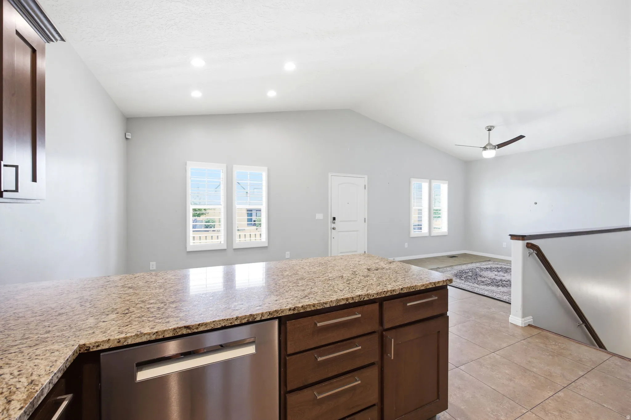 Kitchen island with a granite-style countertop and integrated stainless steel dishwasher