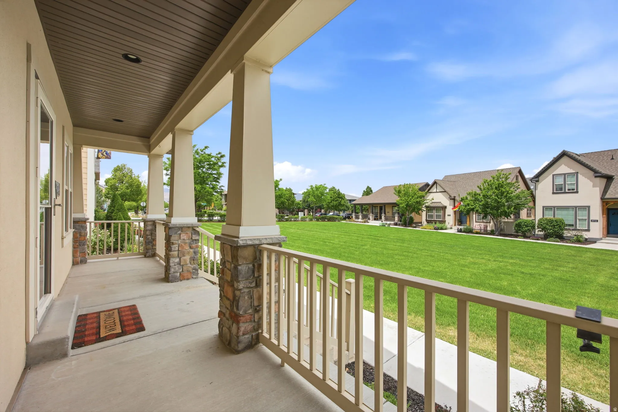 Covered porch with stone-accented pillars and an overhead recessed light