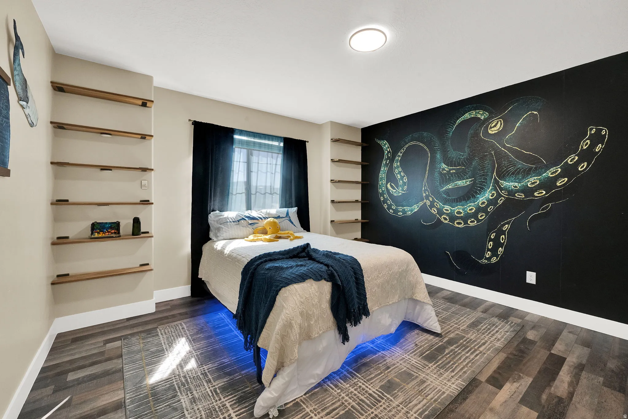 Accent wall with custom artwork, recessed lighting, and wood-finish flooring
