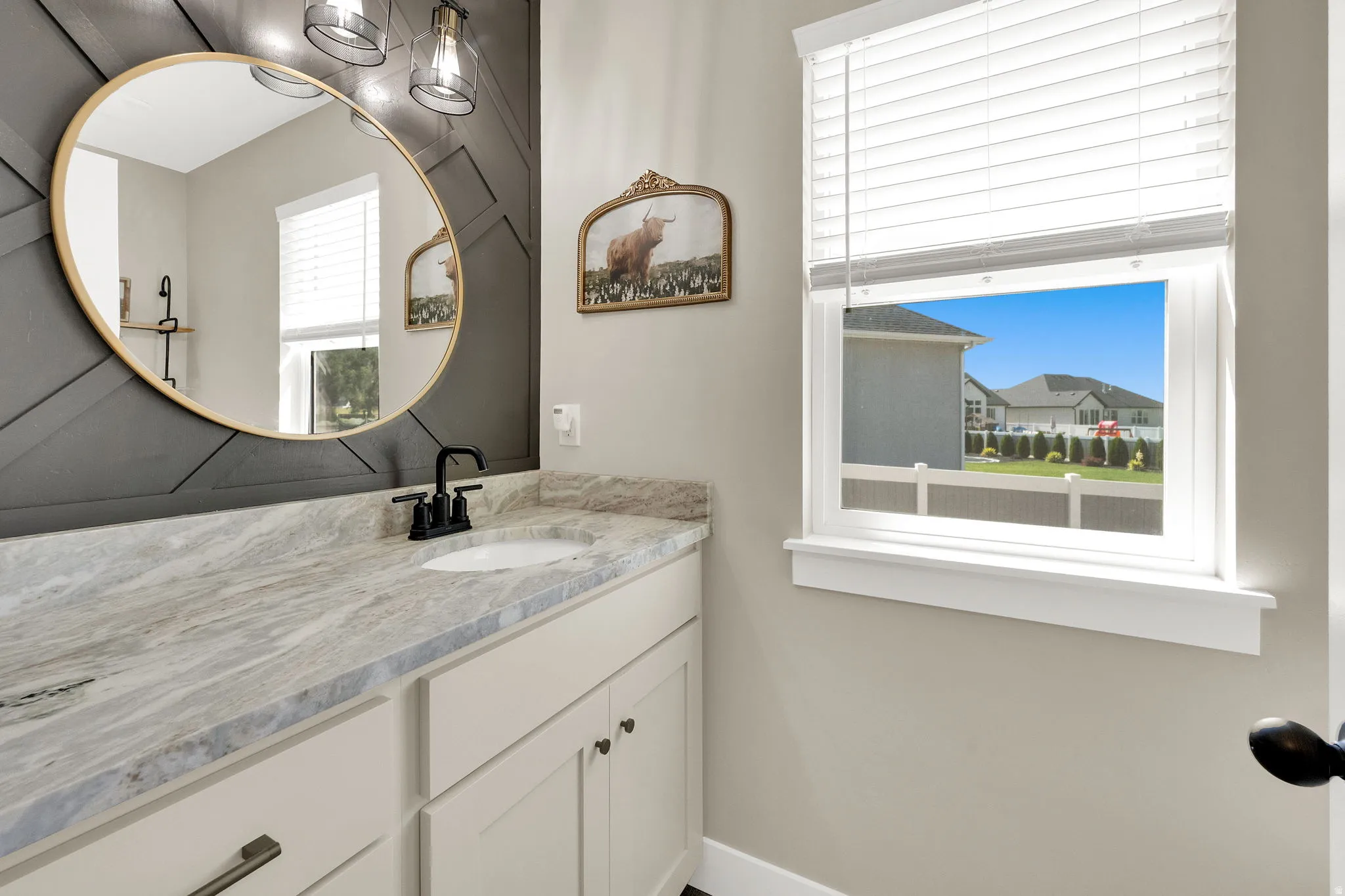 Bathroom vanity featuring a vessel sink, patterned countertop, and matte black faucet