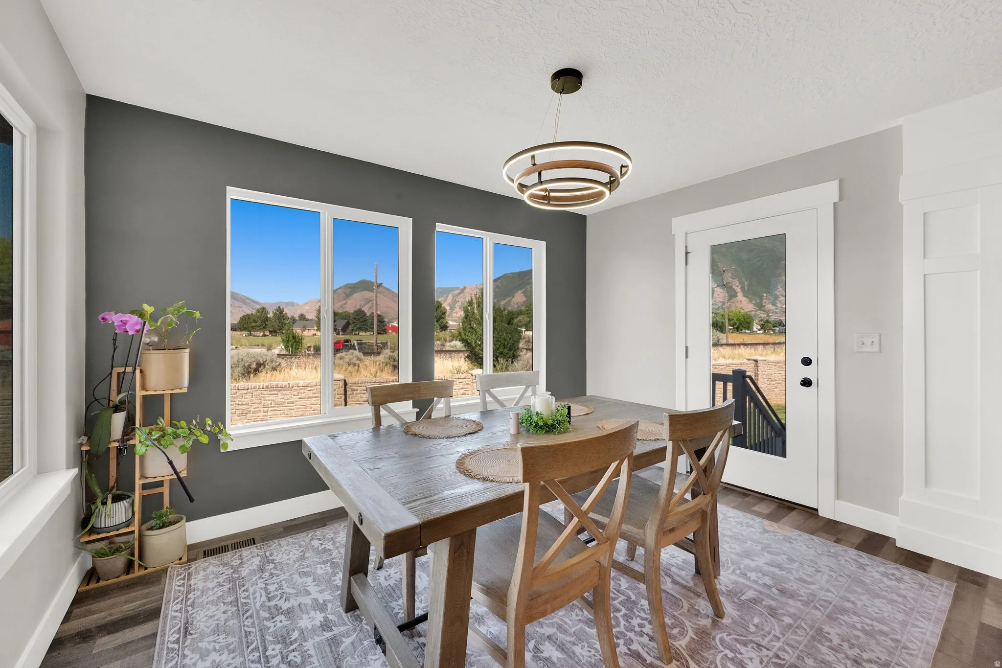 Dining area with wide plank wood-finish flooring and a contemporary ring chandelier
