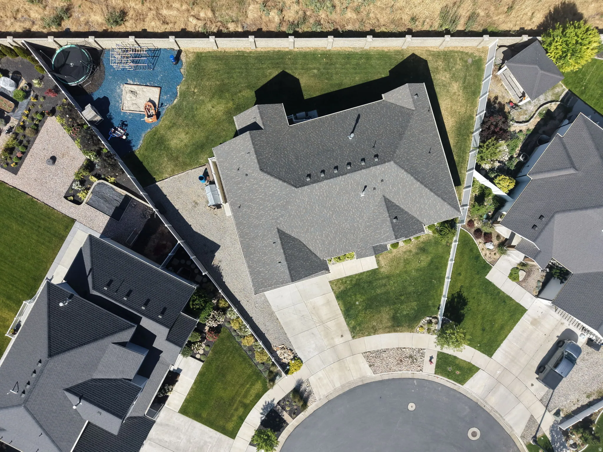 Expansive residential property featuring a cul-de-sac location, paved driveway, mature landscaping, fenced rear yard, and an asphalt shingle roof
