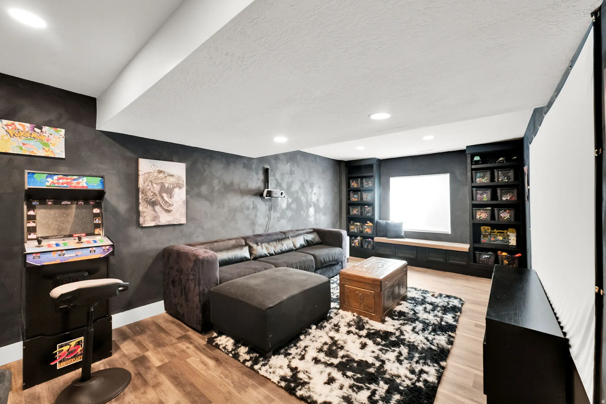 Entertainment room featuring wood-finish flooring, recessed lighting, and a built-in window seat with integrated shelving