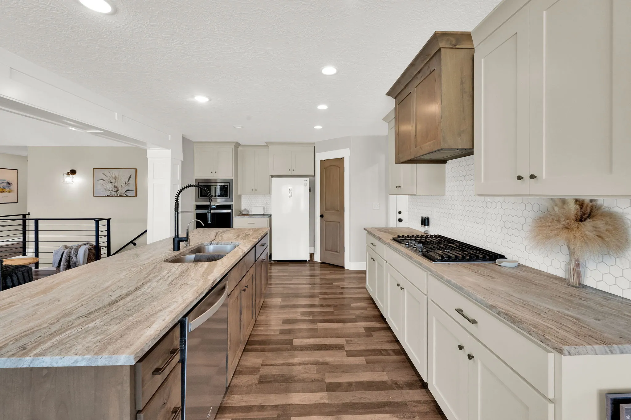 Kitchen featuring a long island with an undermount sink and stainless steel dishwasher
