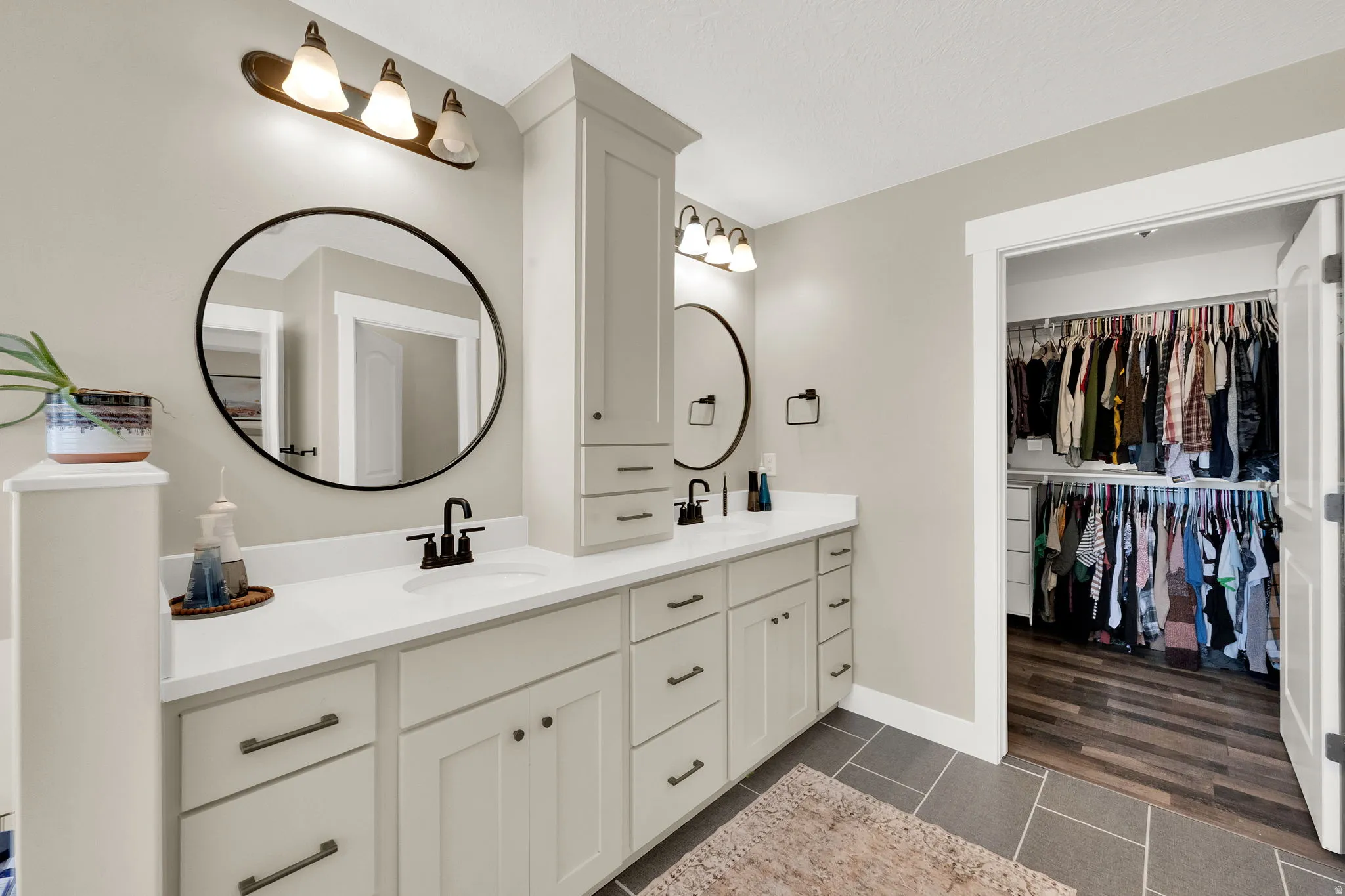 Dual vanity with light-toned cabinetry, quartz countertops, and matte black fixtures