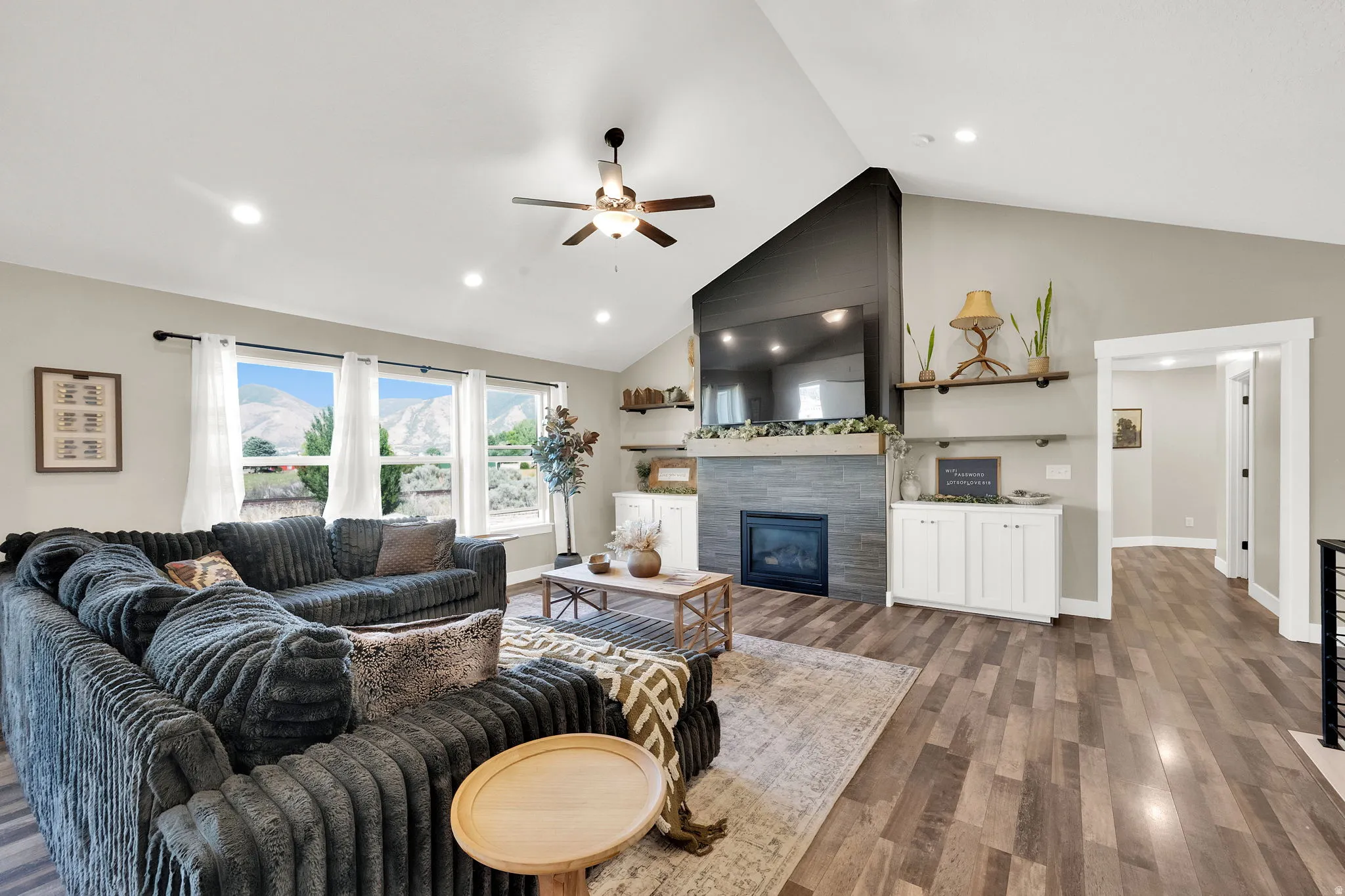 Spacious living area featuring a vaulted ceiling and wood-finish flooring