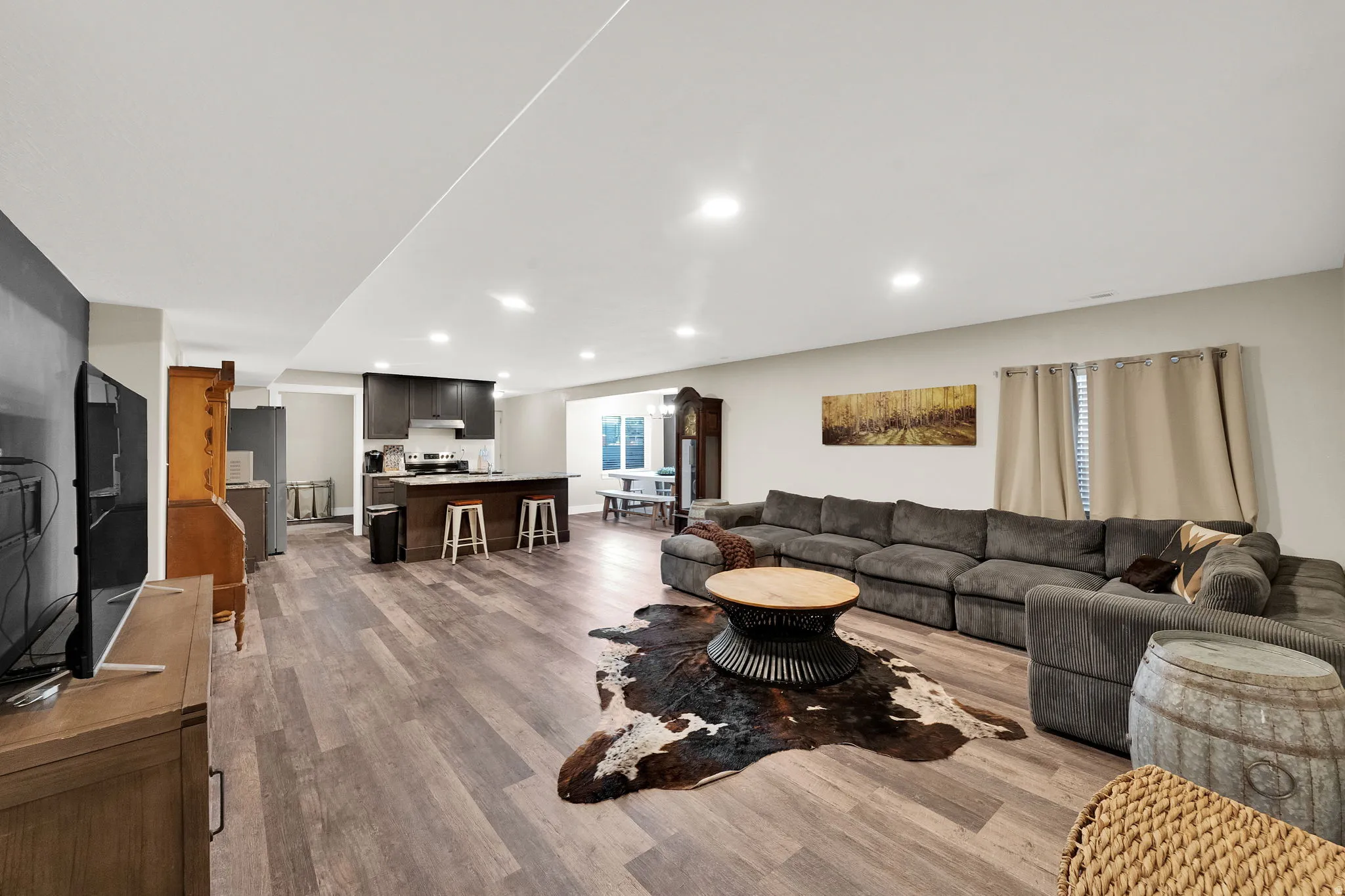 Open-concept living space featuring wood-finish flooring, recessed lighting, and a neutral color palette