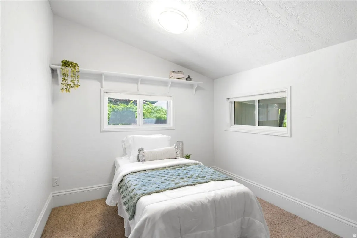 main level bedroom/ featuring a vaulted ceiling with recessed lighting
