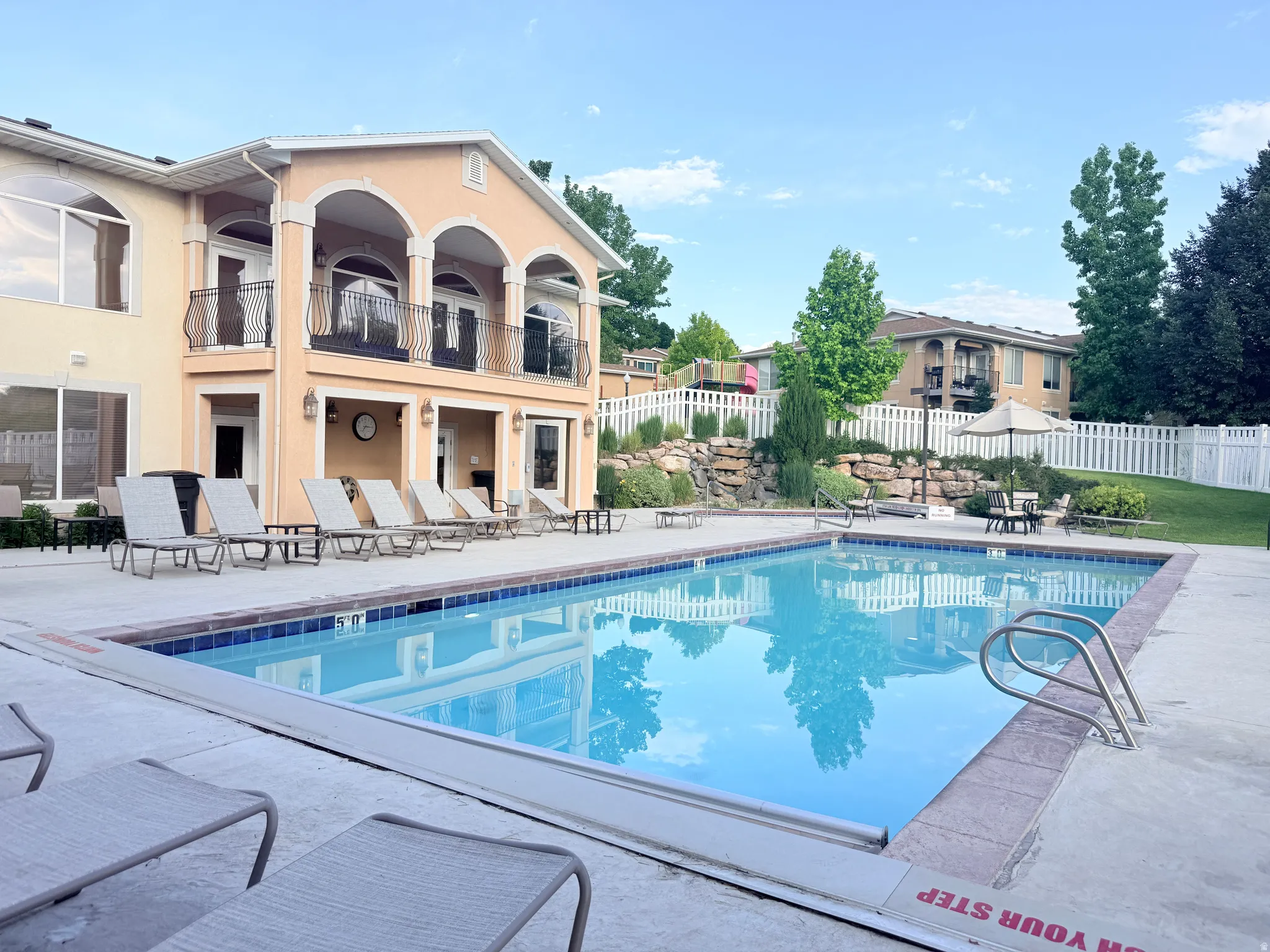 Rectangular swimming pool with integrated steps, surrounded by a concrete deck