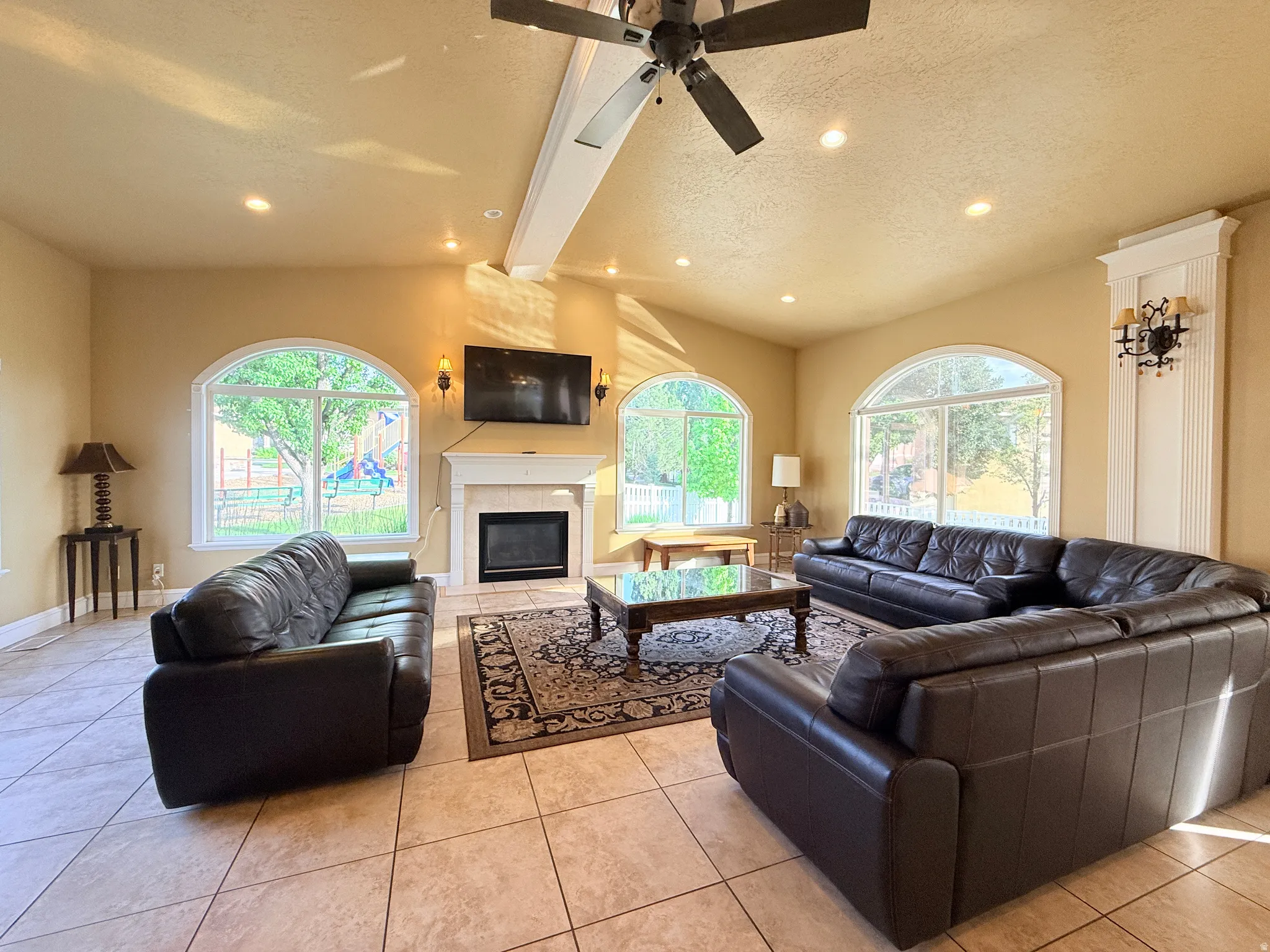 Living area featuring vaulted ceilings with exposed beam, recessed lighting, and a ceiling fan