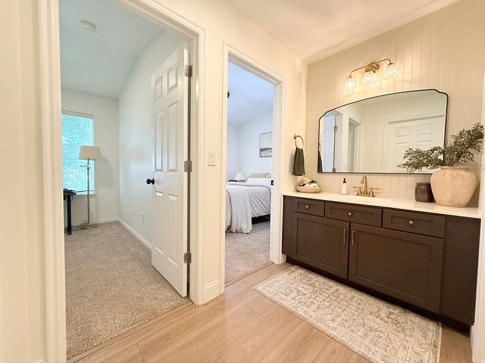 Bathroom vanity featuring dark wood cabinetry, a light-toned countertop, and a decorative framed mirror