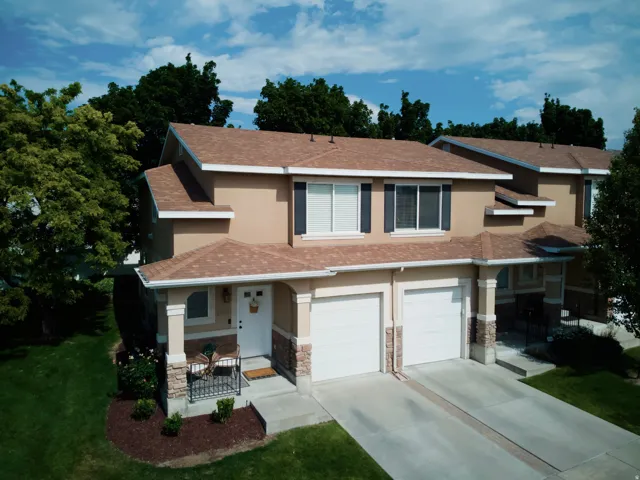 Stucco exterior with a covered porch entry featuring stone accents and decorative railing