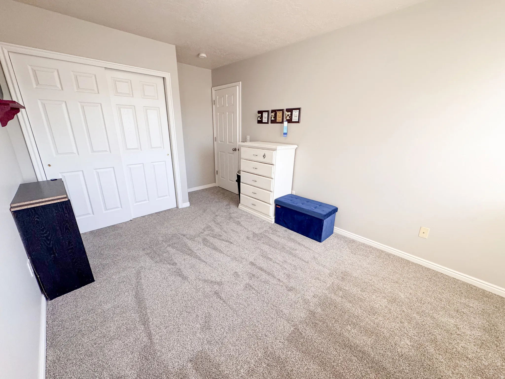 Room with light gray walls and plush gray carpeting