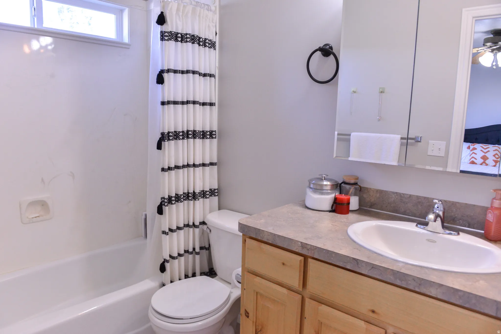 Full bathroom featuring a single vanity with wood cabinetry, a light-toned countertop, and an integrated sink