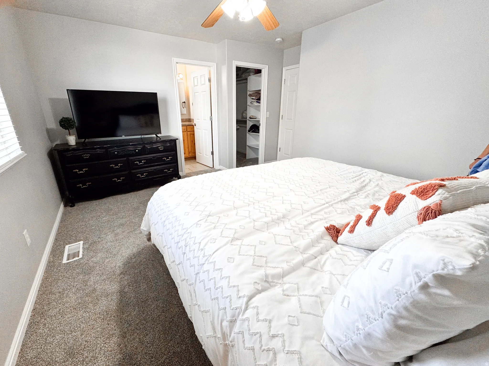 Carpeted room with a ceiling fan light fixture, light gray walls, and white trim