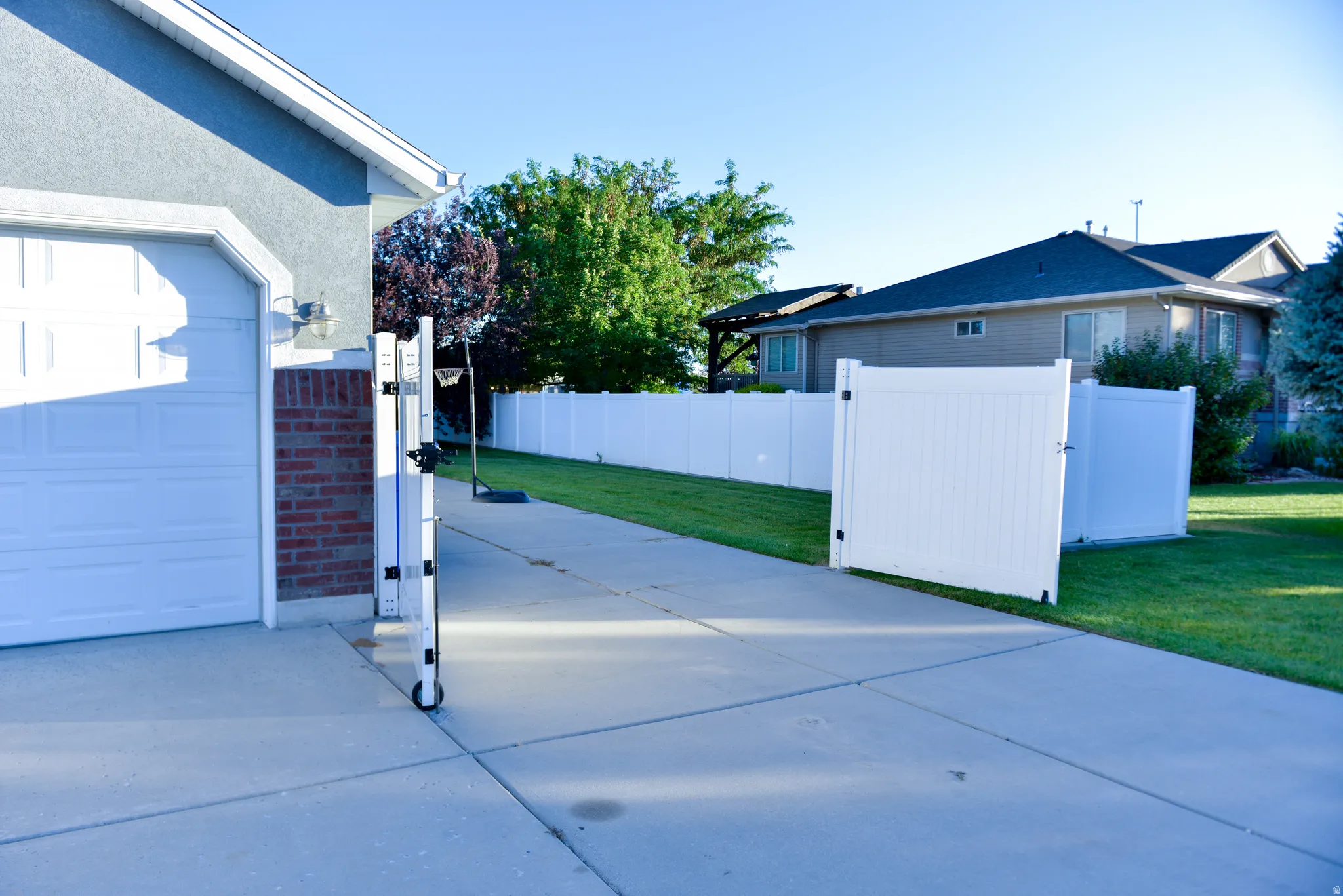 Concrete driveway with a vinyl privacy fence