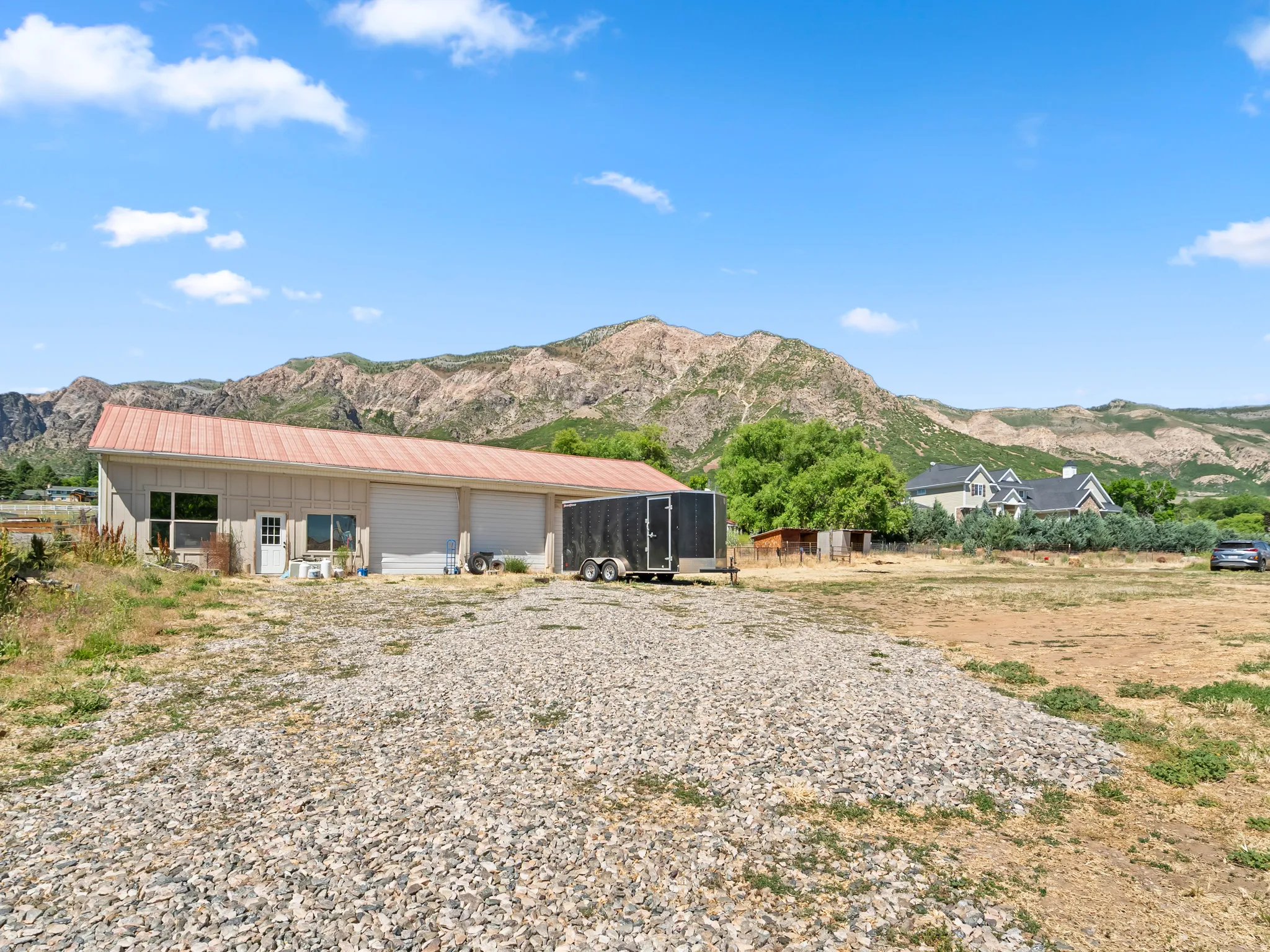 Spacious outbuilding featuring a metal roof, multiple garage doors, and a pedestrian entry
