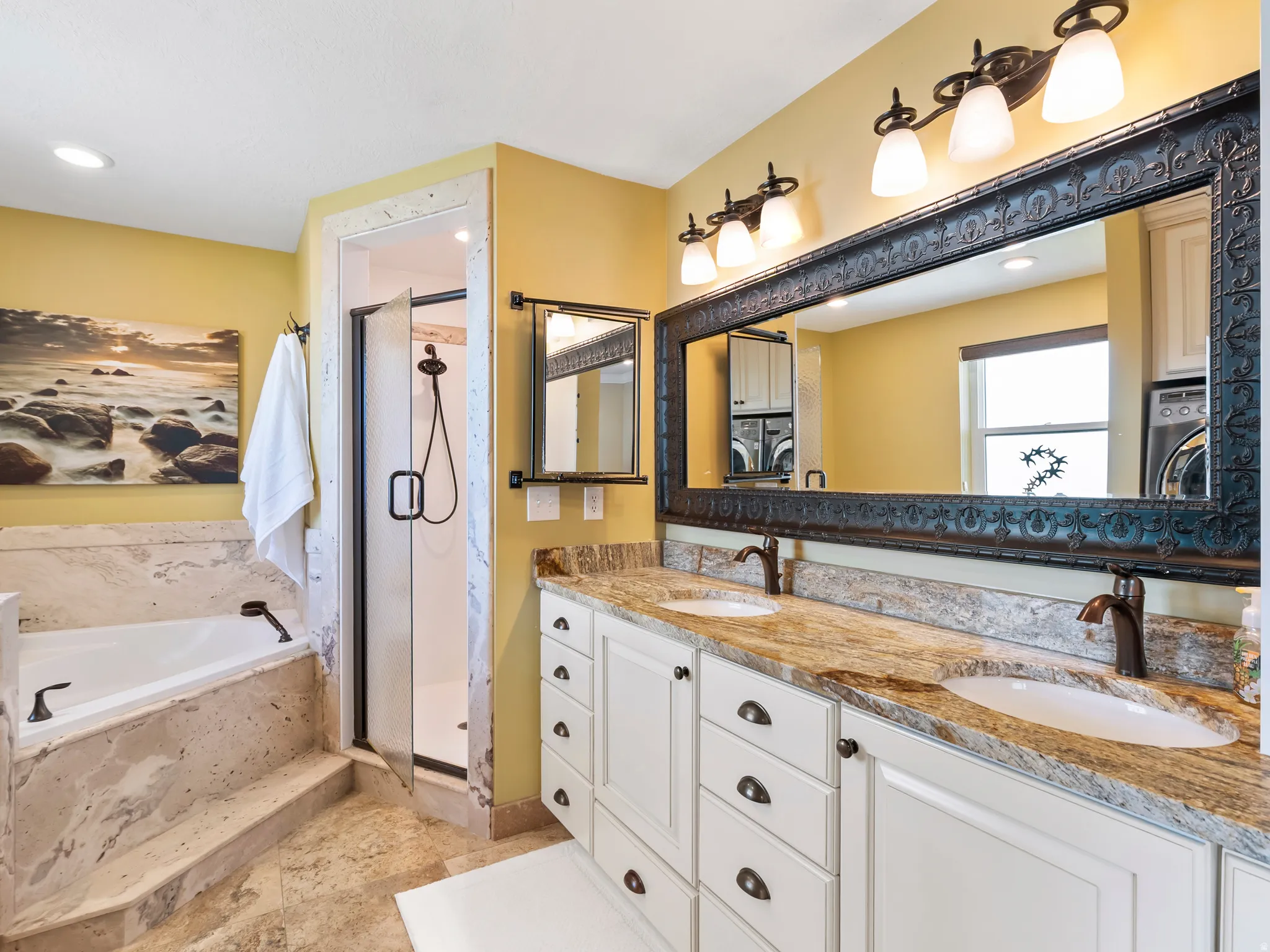 Dual vanity featuring white cabinetry, granite countertops, and bronze fixtures
