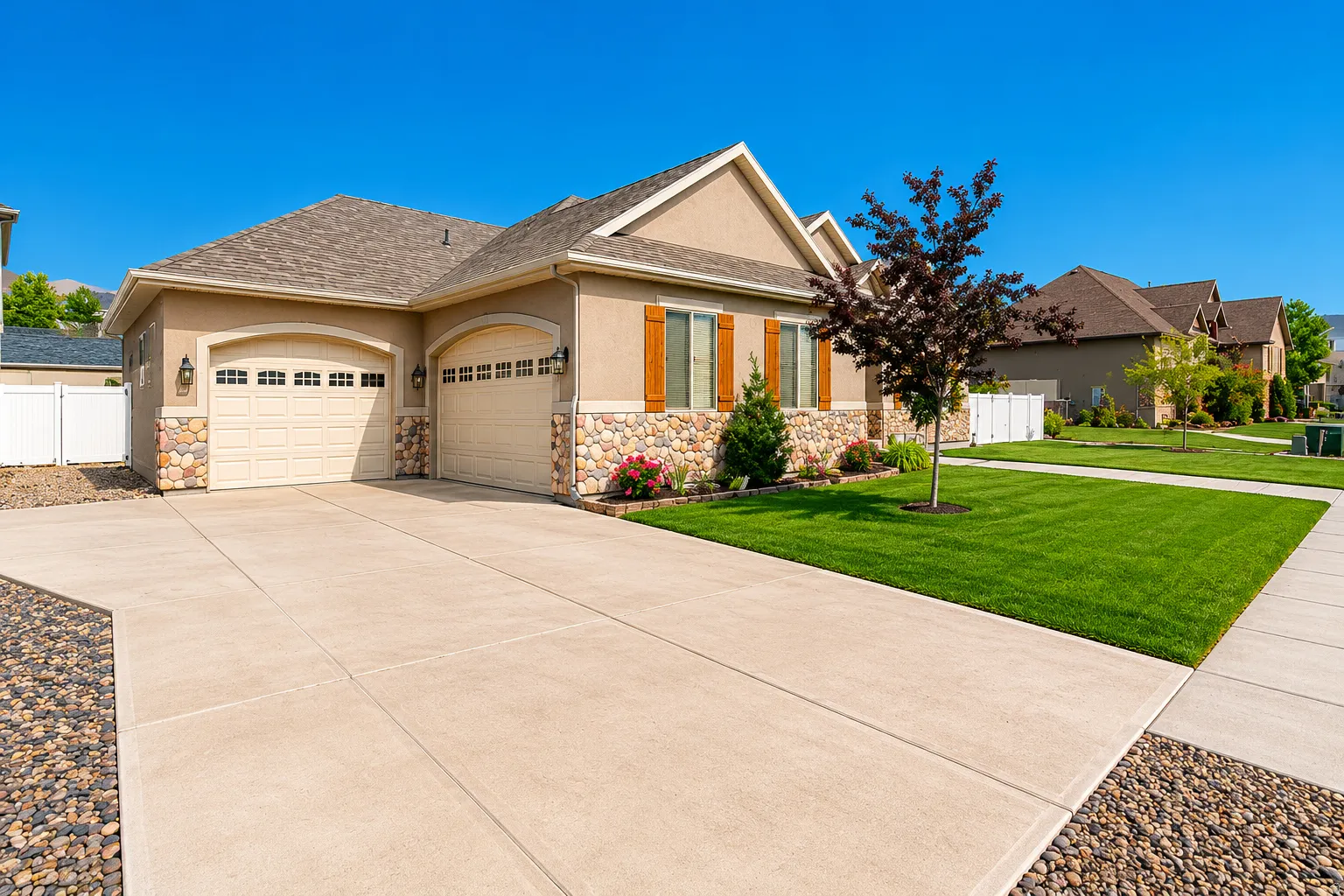 Exterior featuring stucco and stone veneer siding, a two-car garage with carriage-style doors, and a concrete driveway