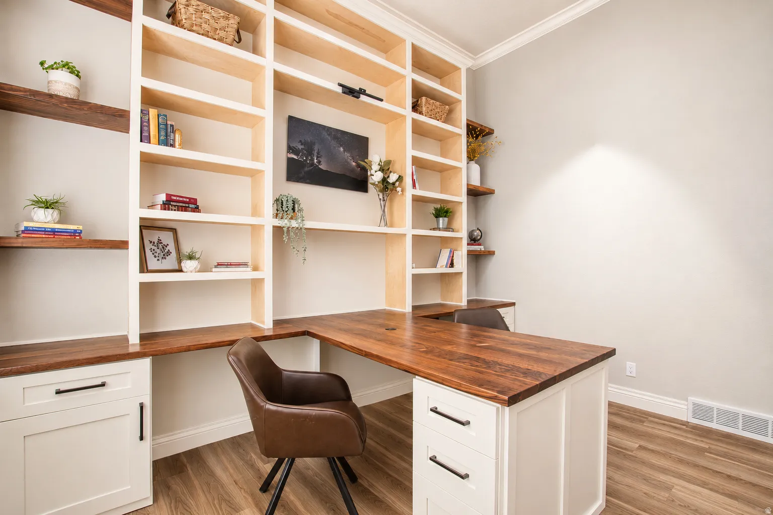 Built-in custom shelving and desk system featuring wood-finish countertops and white cabinetry