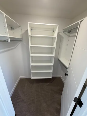 Integrated closet system featuring multiple shelves and hanging rods