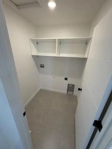 Utility area with built-in overhead cabinetry, recessed ceiling lighting, and tile flooring