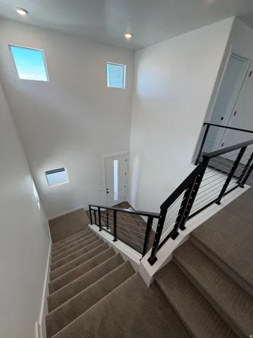 Two-story foyer with high ceilings, recessed lighting, and multiple windows