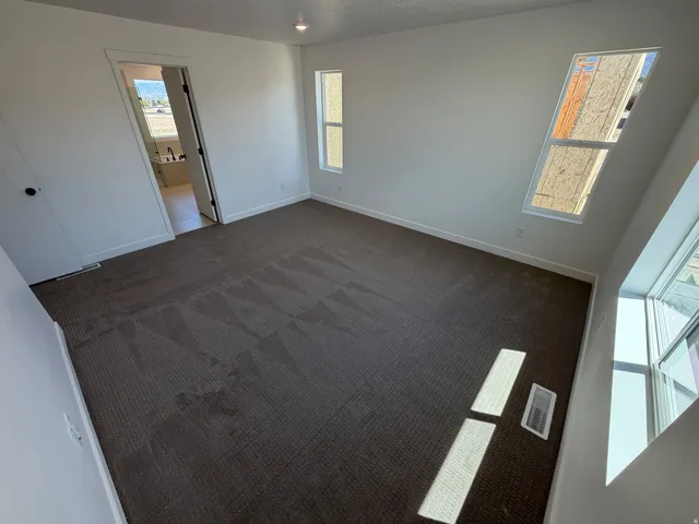 Neutral wall finishes with a spacious layout, recessed lighting, and carpeted flooring