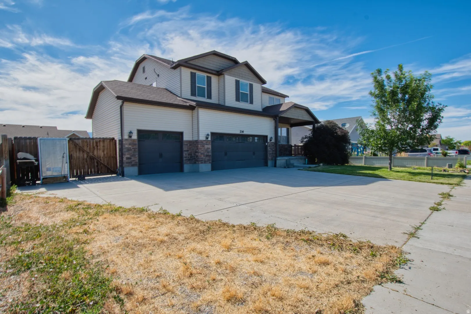 Two-story property featuring a multi-car driveway and an integrated two-car garage with RV parking