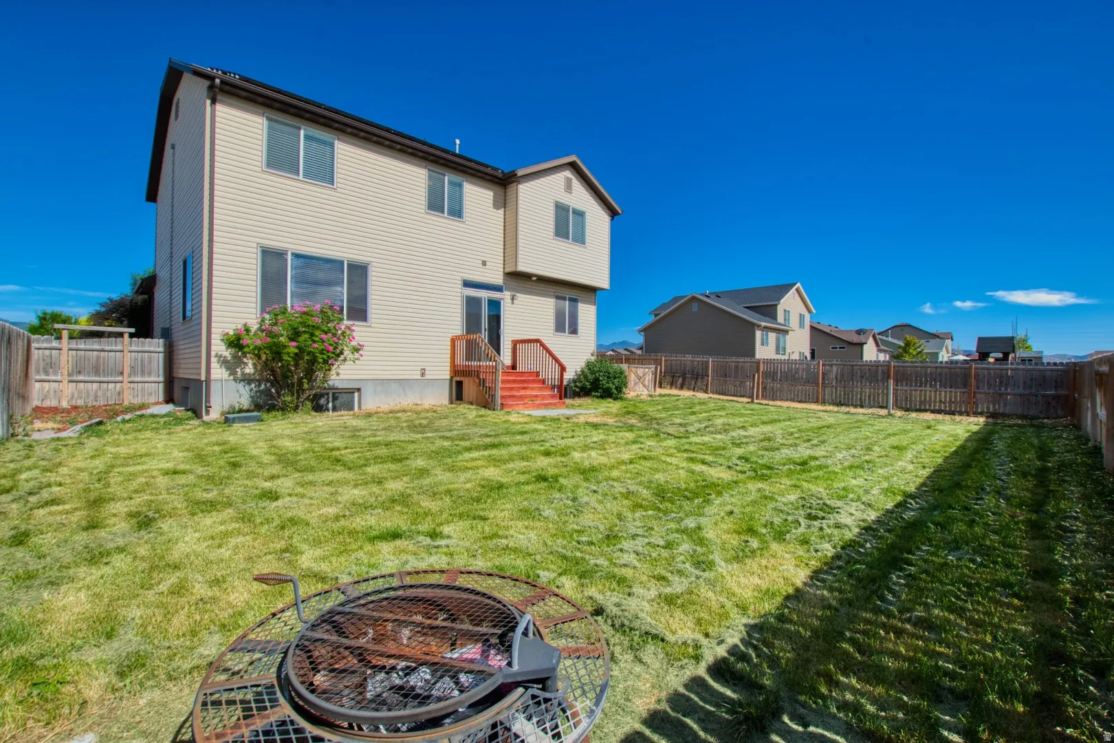 Expansive green lawn with a full wooden privacy fence