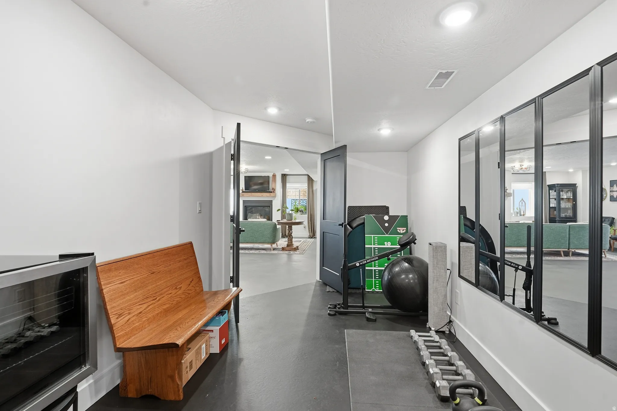 Hallway with durable flooring, recessed lighting, and a full-height paneled door