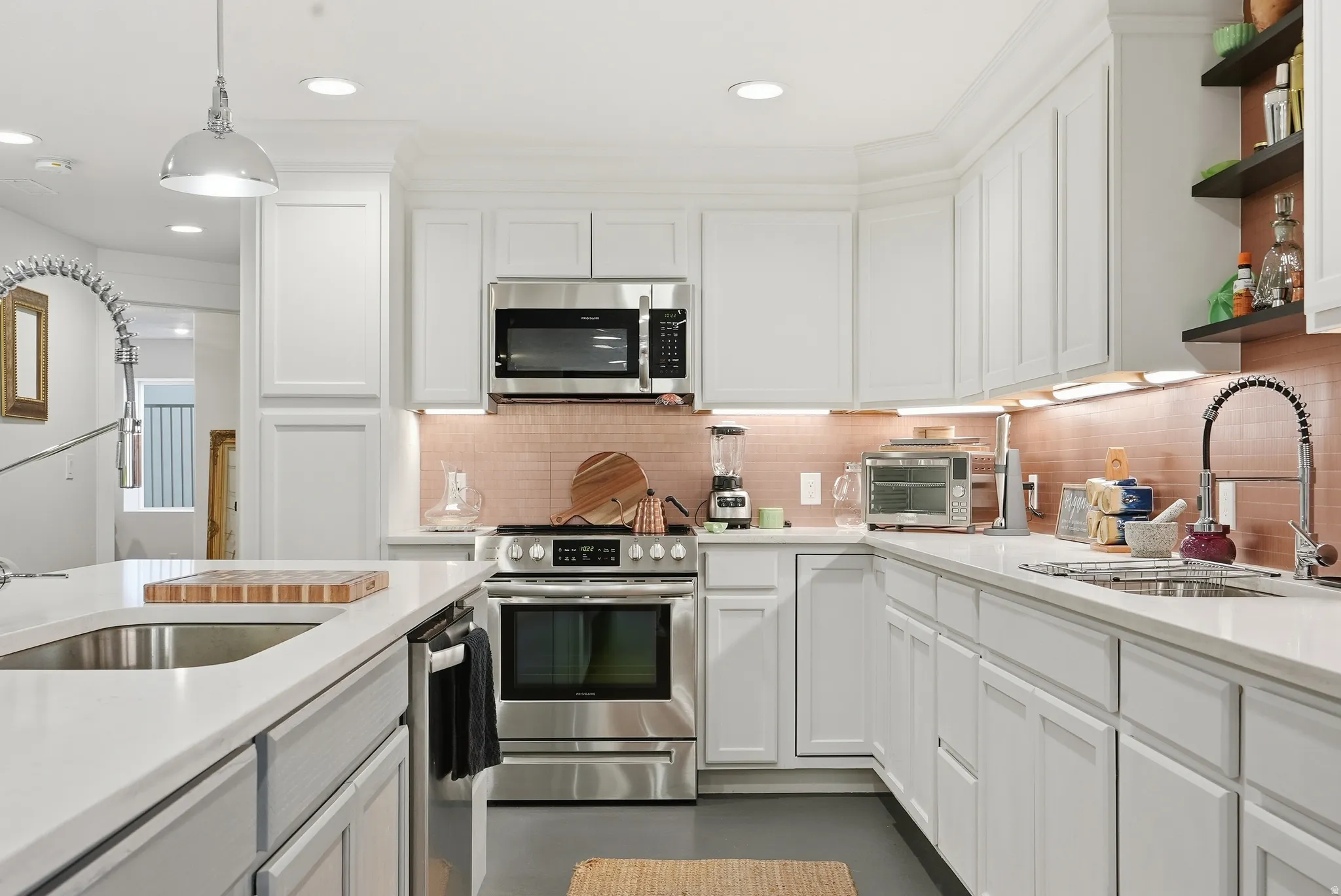 Modern kitchen featuring abundant white shaker cabinetry, stainless steel appliances, white countertops, and a tiled backsplash