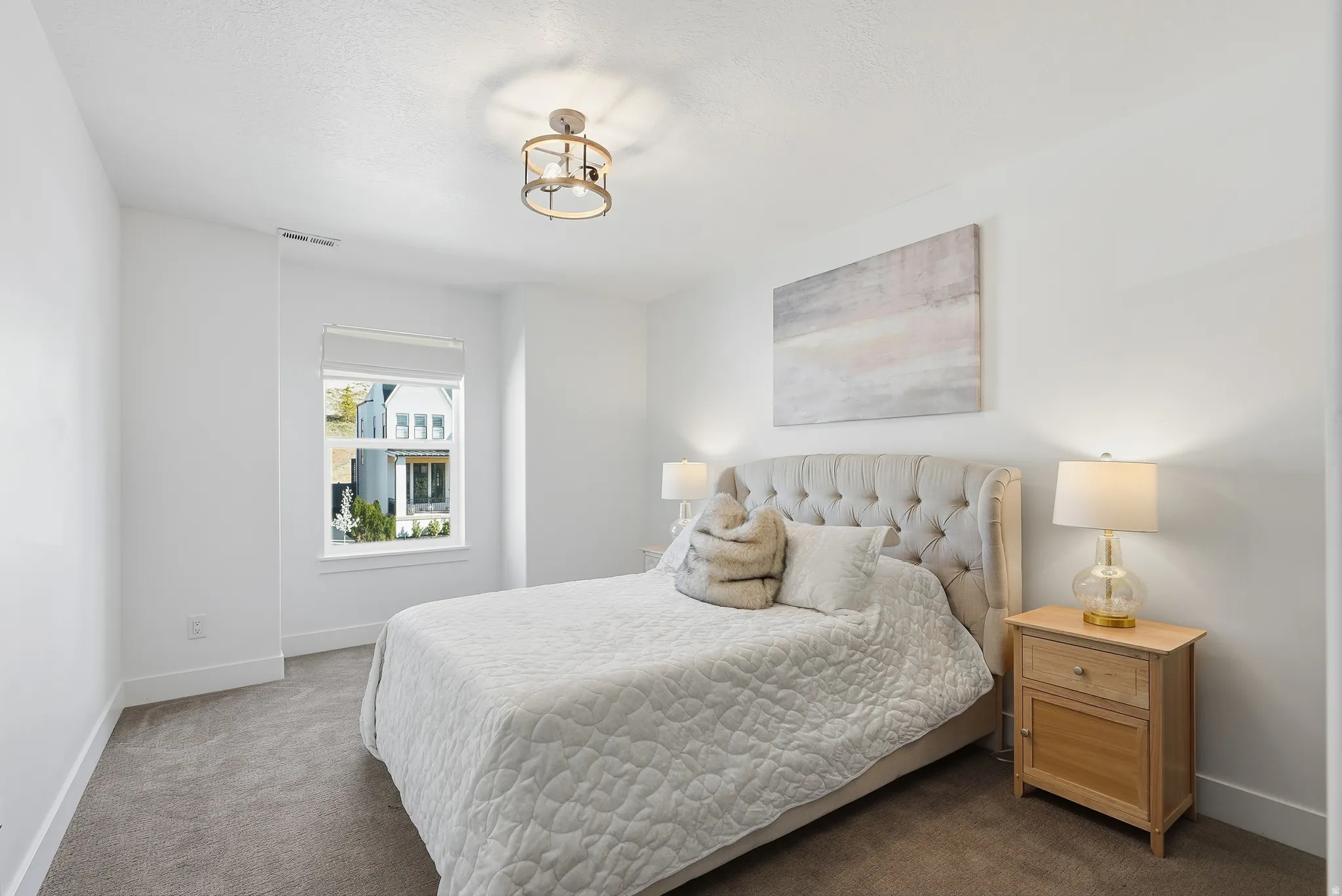 Textured carpet flooring, white painted walls, and a single window with blinds