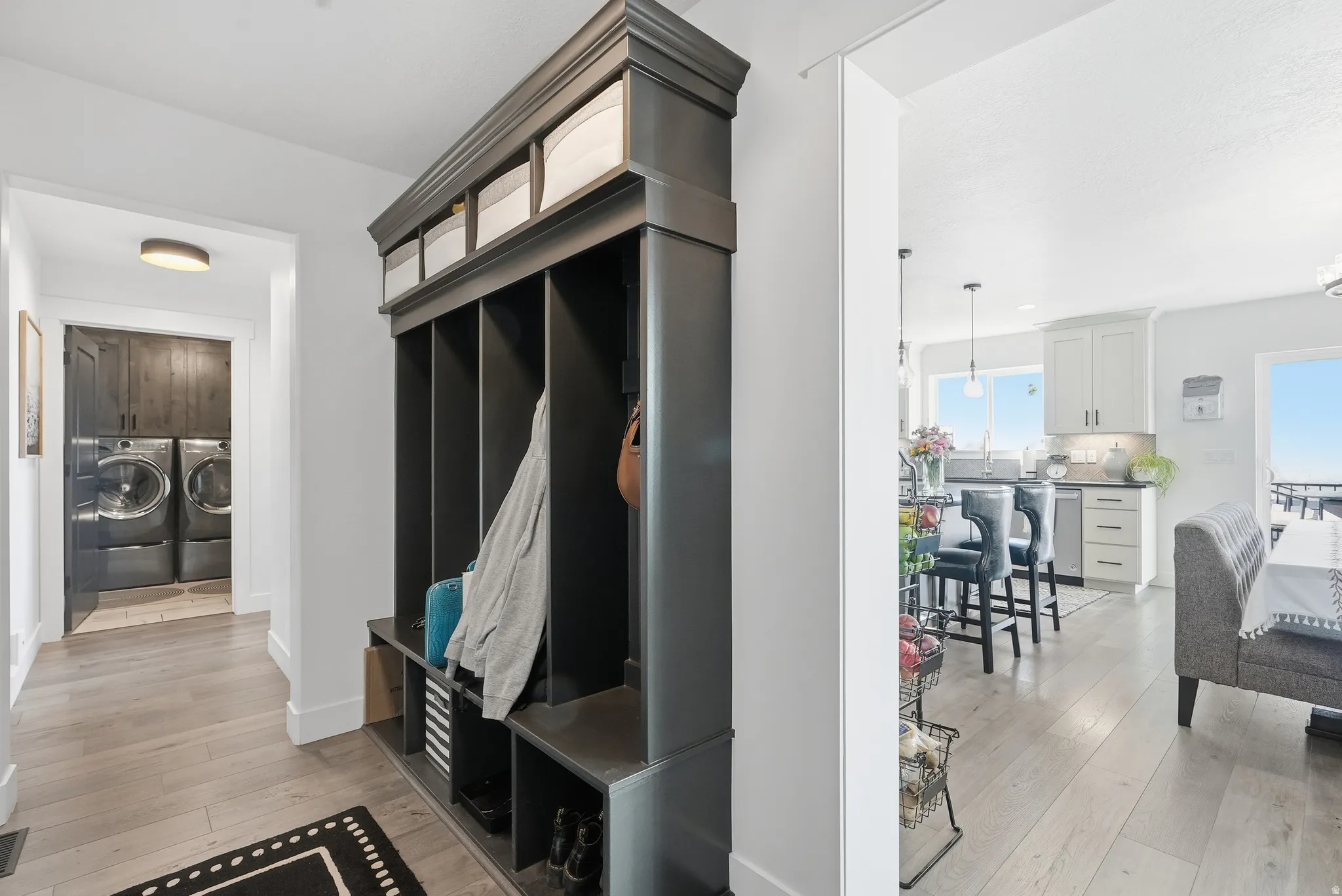 Built-in mudroom storage with multiple compartments and upper shelving