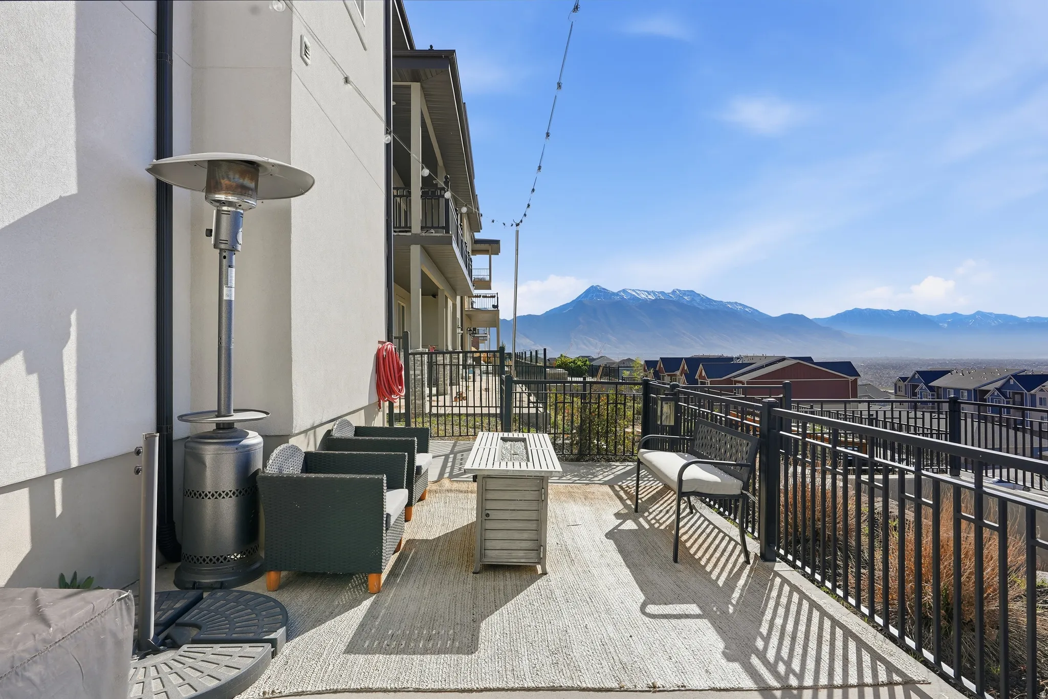 Expansive concrete patio with black metal railings, offering mountain scenery