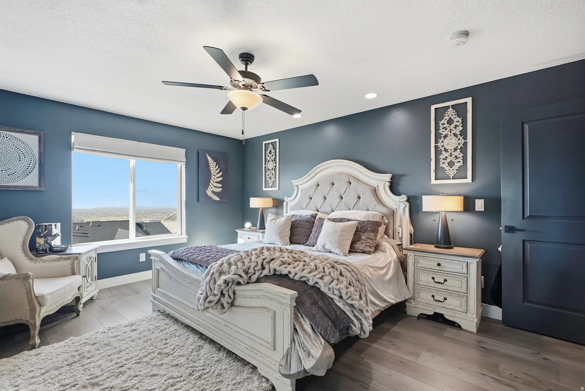 Spacious bedroom featuring wood-finish flooring and deep-toned walls