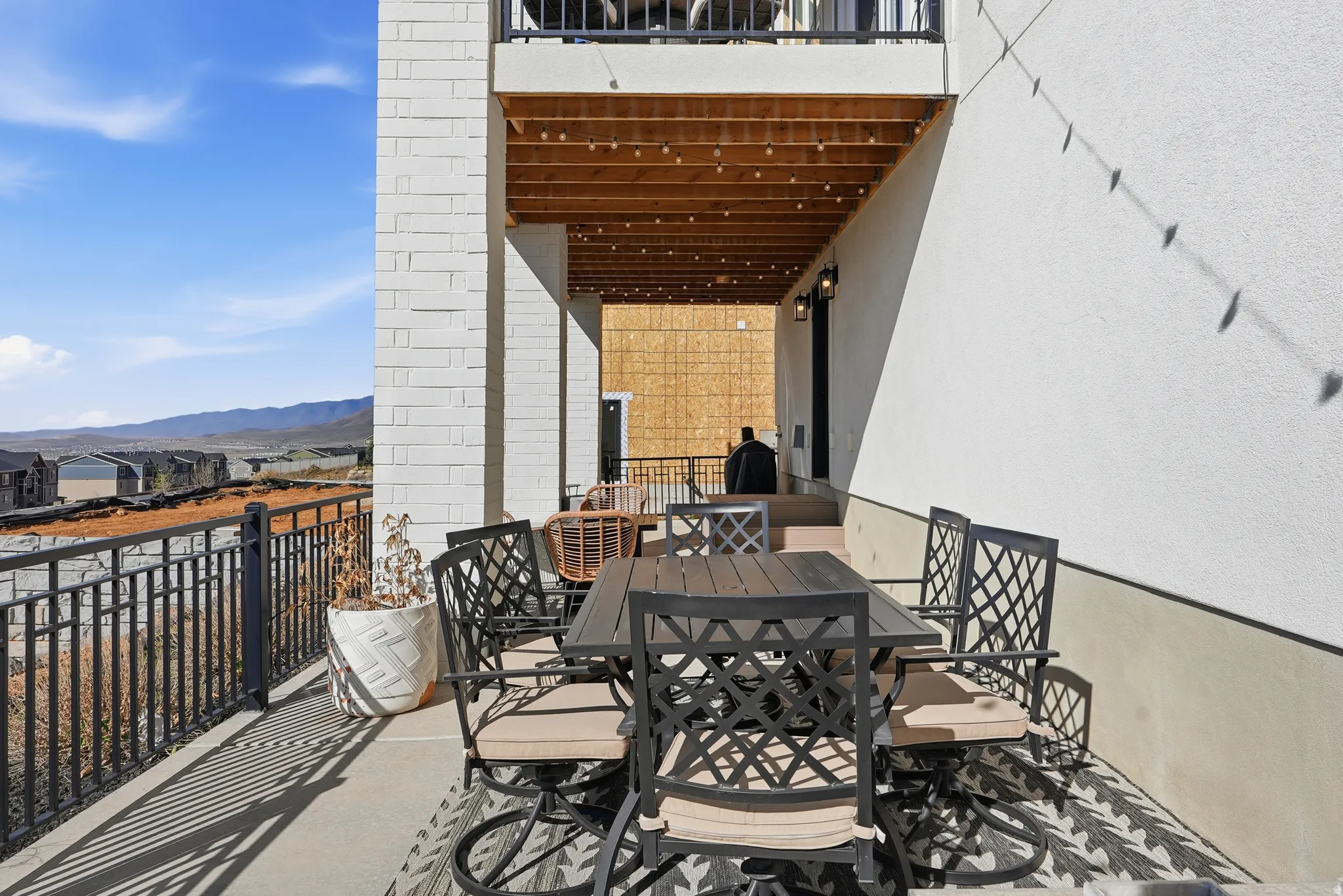Ground-level outdoor patio featuring a concrete surface and black metal railing
