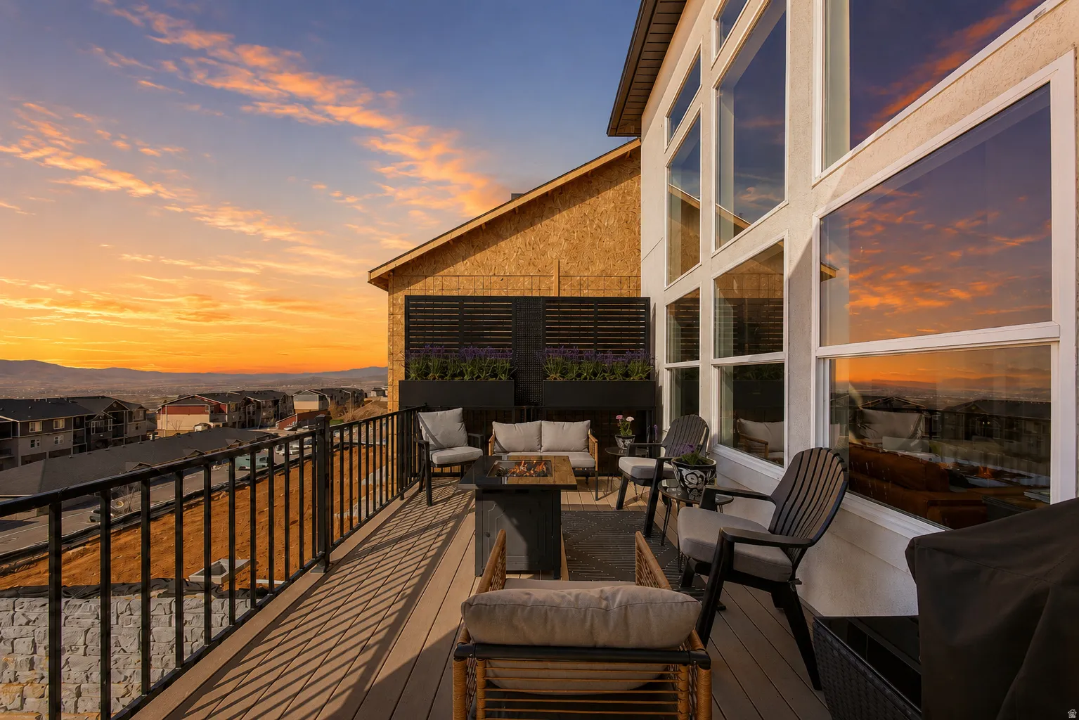 Spacious outdoor deck on main level featuring composite decking, black metal railings, and a prominent floor-to-ceiling window wall