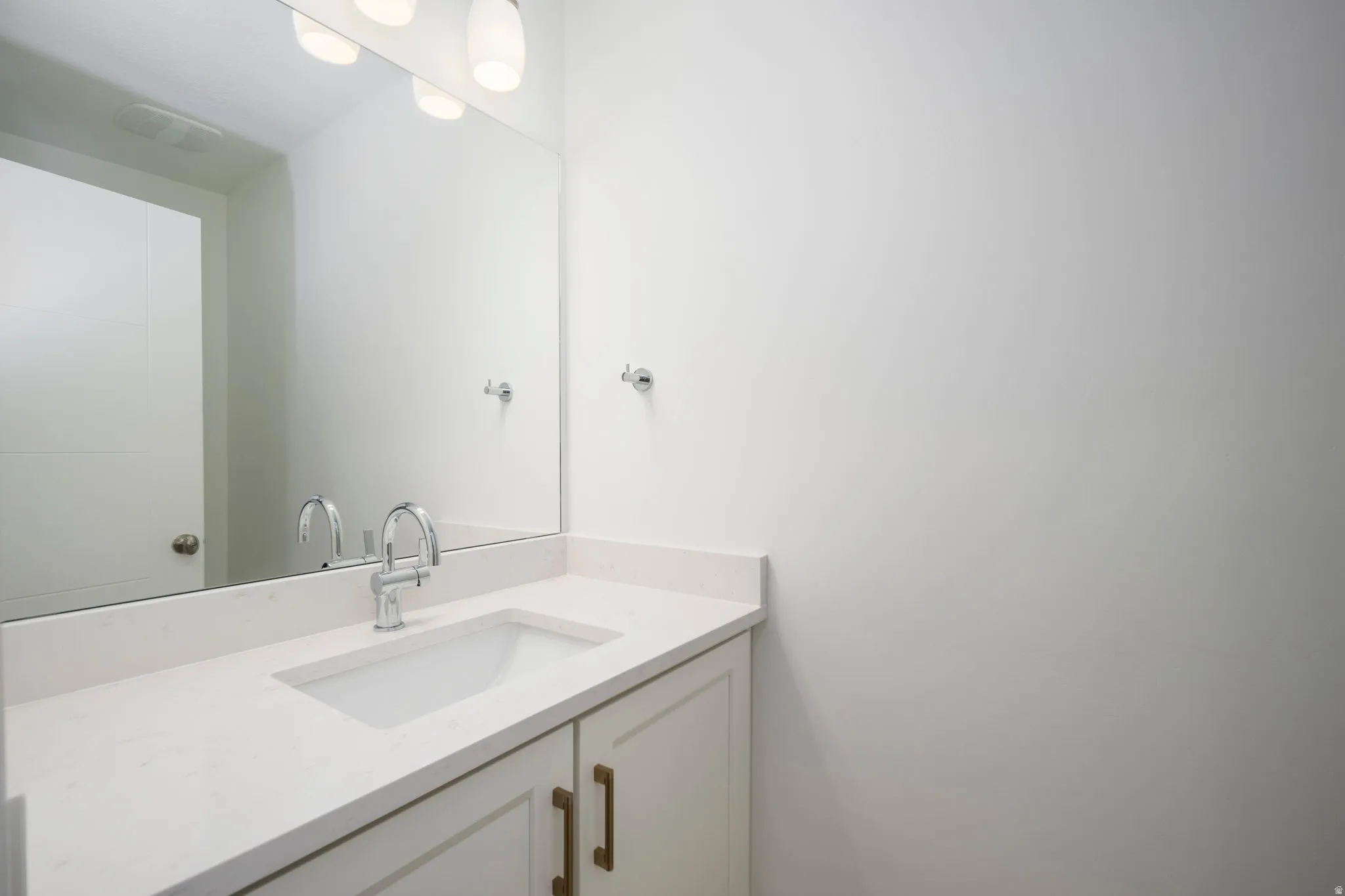 Bathroom vanity with an integrated rectangular sink, light-toned countertop, and chrome faucet