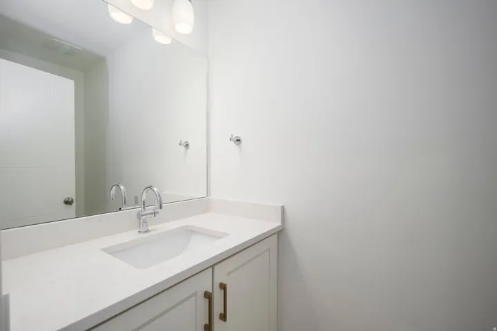Bathroom vanity with an integrated rectangular sink, light-toned countertop, and chrome faucet