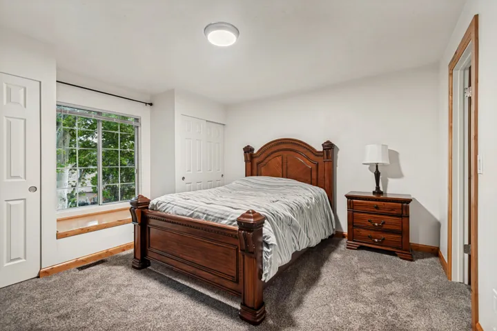 Bright room featuring a large multi-pane window, neutral carpet flooring, a flush-mount ceiling light fixture, and a built-in window ledge