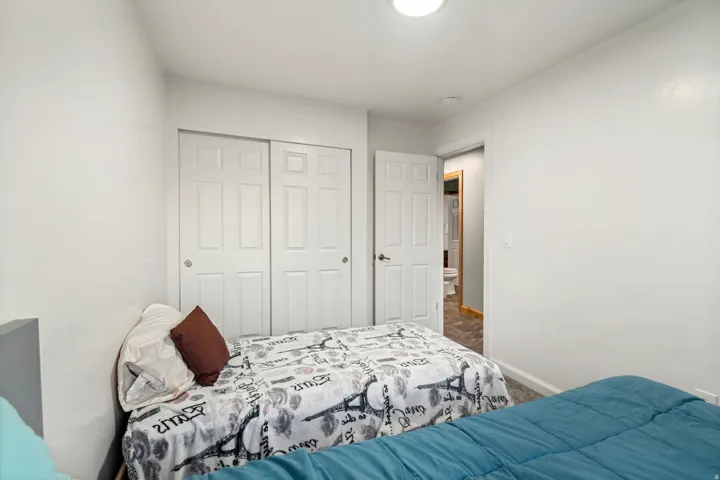 Bedroom featuring two panel closet doors, white painted walls, and recessed lighting