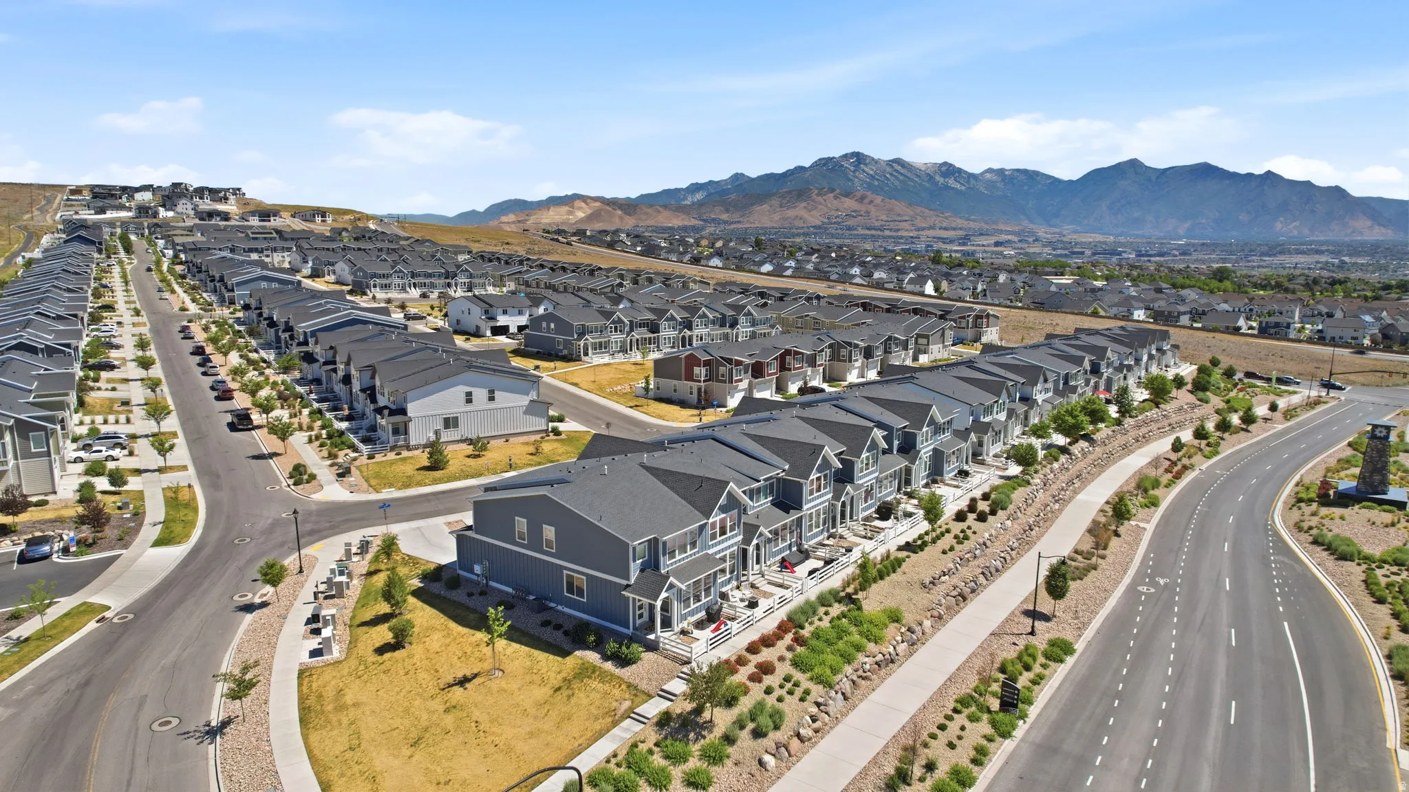 Expansive community featuring numerous multi-story homes with dark gray roofs and light-colored siding