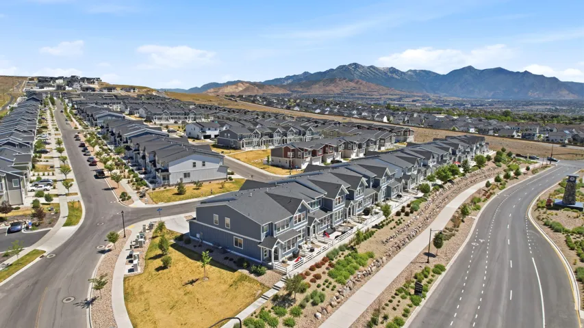 Expansive community featuring numerous multi-story homes with dark gray roofs and light-colored siding