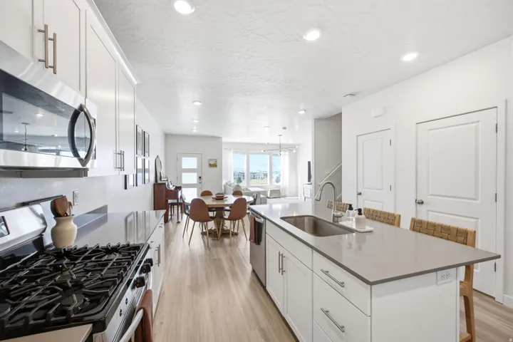 Open-concept kitchen with light wood-finish flooring extending into the dining area
